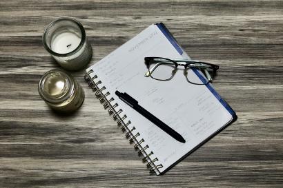 Image of planner with pen and glasses on a table