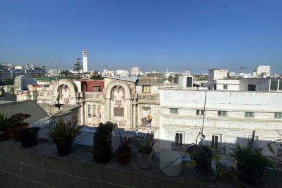 View of Casablanca showing apartment buildings, mosques, the Hassan II Mosque, and a clear blue sky