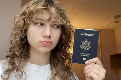 A young woman holds her passport