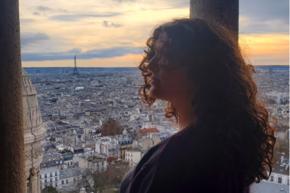 A girl at the top of the Sacre Coeur looks out to the Eiffel Tower and ponders how lucky she is to see such a sight and how beautiful the world is.