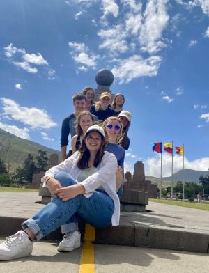 a group of students pose in front of Mitad del Mundo for a fun photo