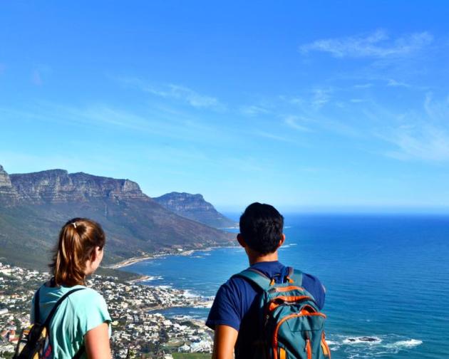 two students look over Cape Town's city and coastline from the mountaintops