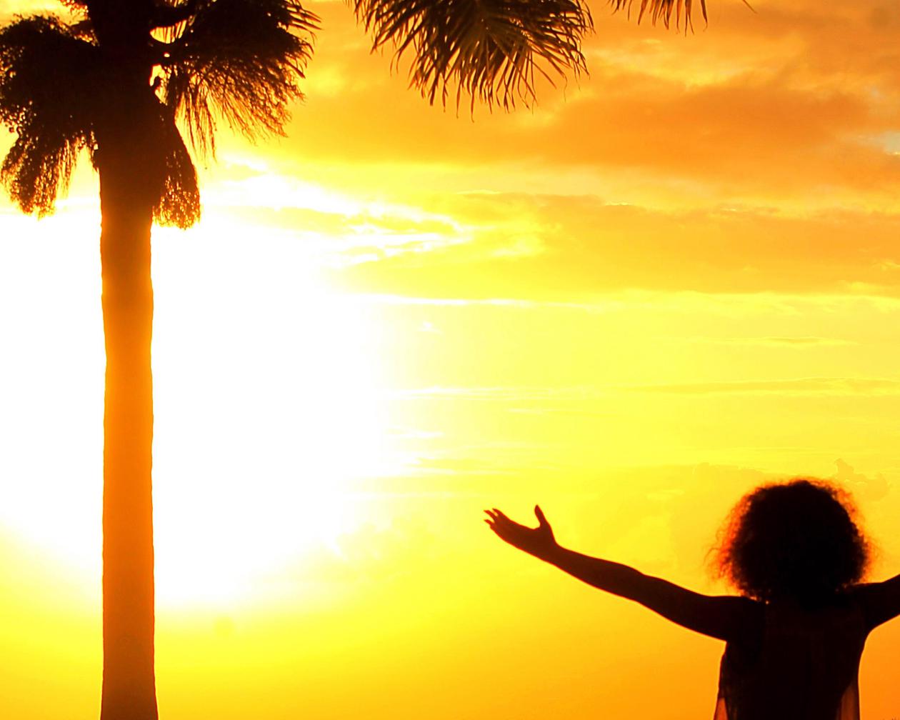 A woman enjoys the sunset by the beach
