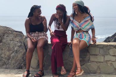 three black students laughing by the sea