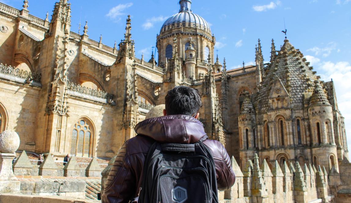 a student looking up at the beautiful New Cathedral of Salamanca