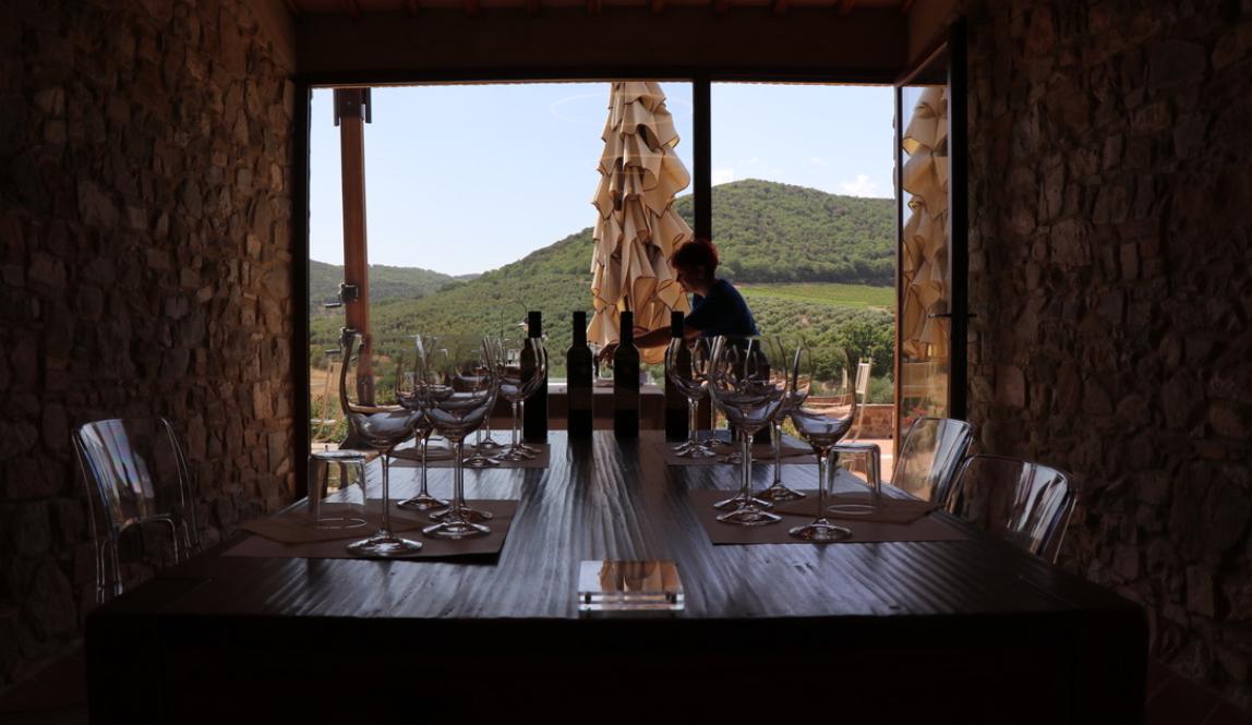 a table set for a wine tasting in Siena in front of an open window with mountains