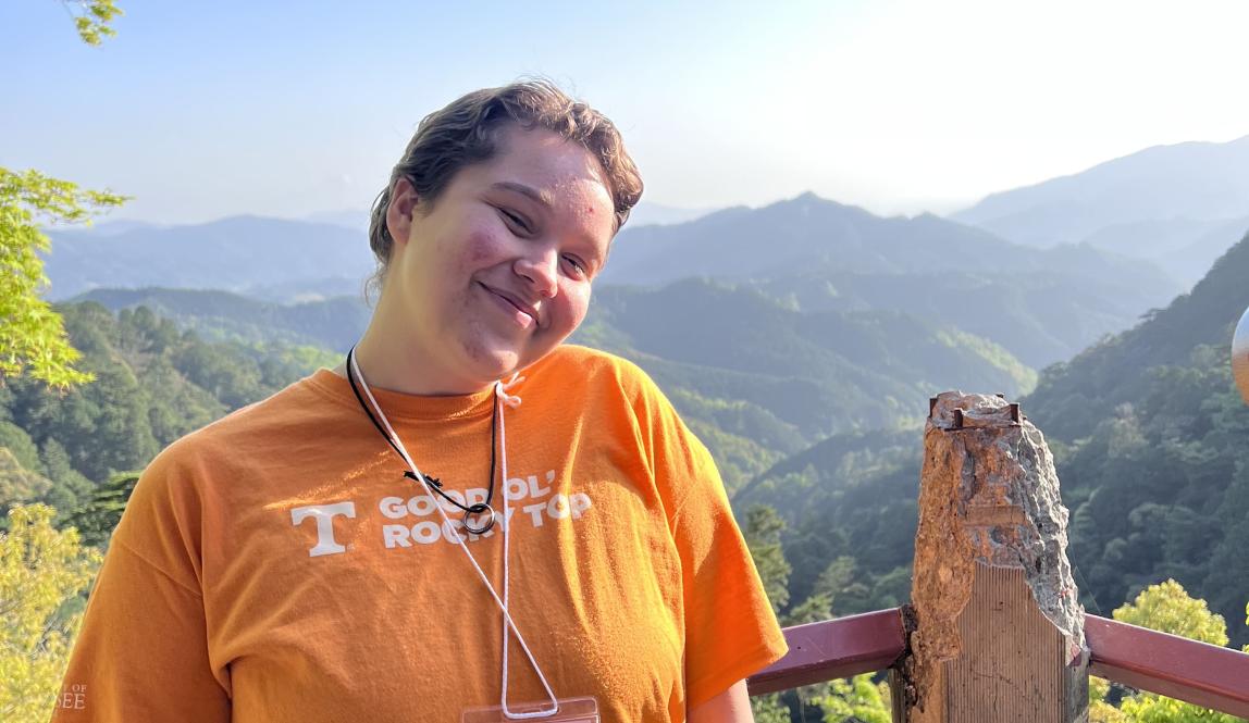 Author, Macks, standing in front of a view from hiking in the mountains.