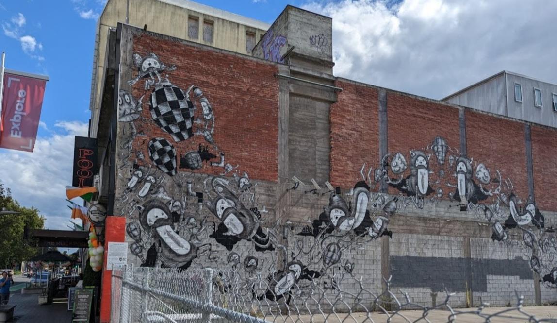 A mural of cartoon characters cascading across a brick wall