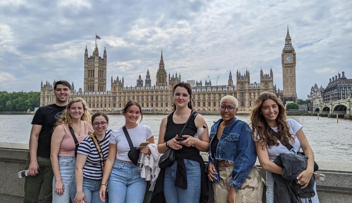 A group of students posing for a photo in front of British Parliament and the River Thames
