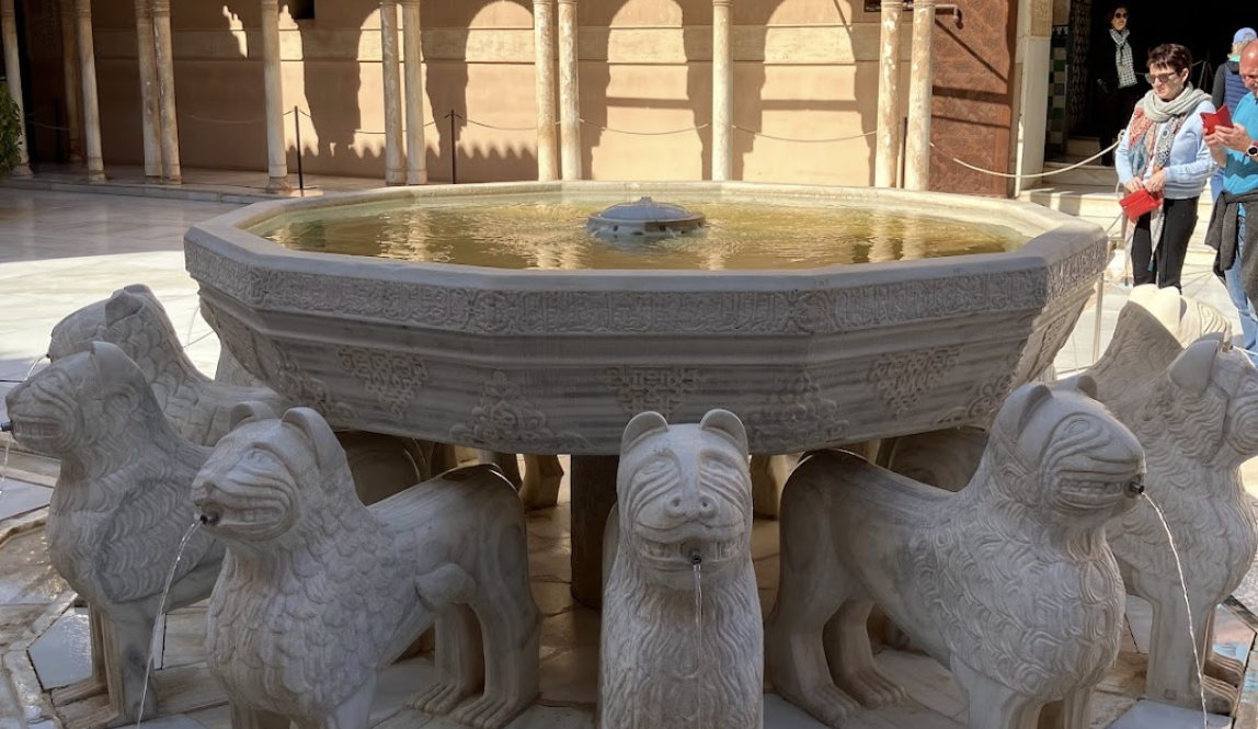 round fountain supported by marble lions