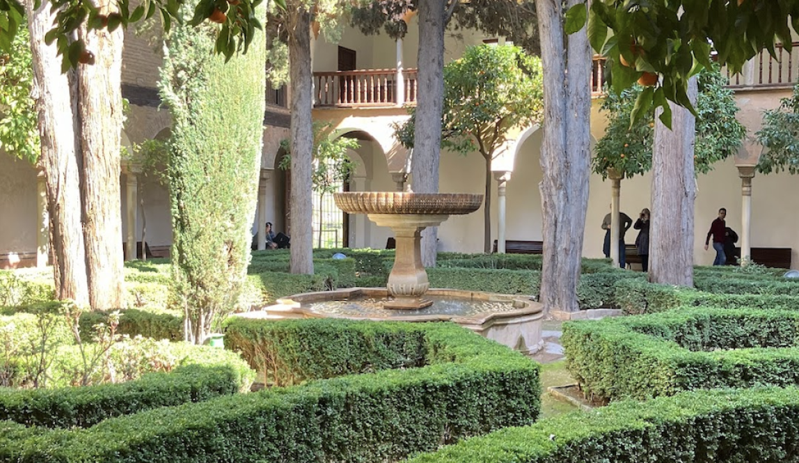 Garden with fountain, trees and pentagonal hedges