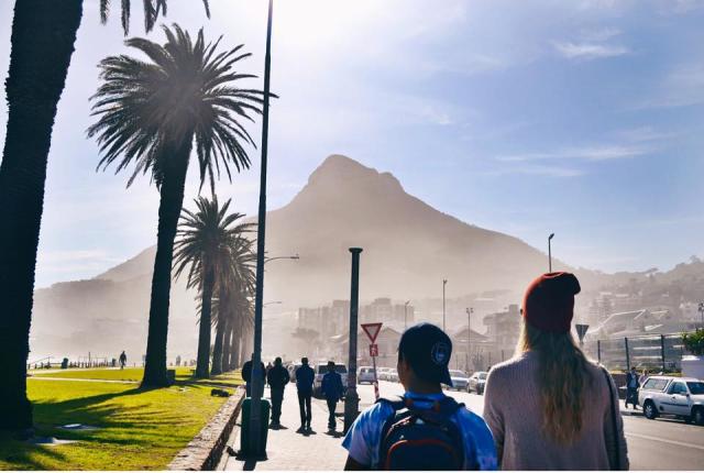 students going for a walk on the palm tree-lined sidewalk in Cape Town