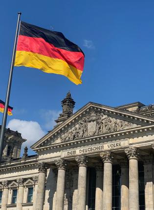 the German flag waving in front of Bundestag in Berlin