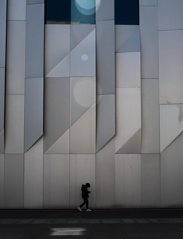 a student walking alongside modern architecture