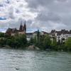 Perspective of the Rhein and Basel Münster, clouds against blue sky, leafy trees, ripples along the river 
