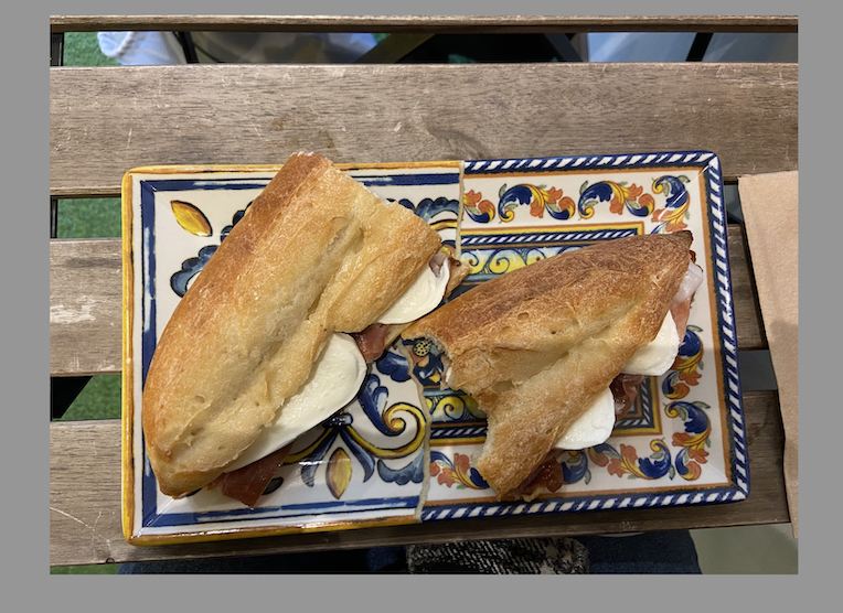 mozarella and prosciutto sandwich with fig jam on a roll