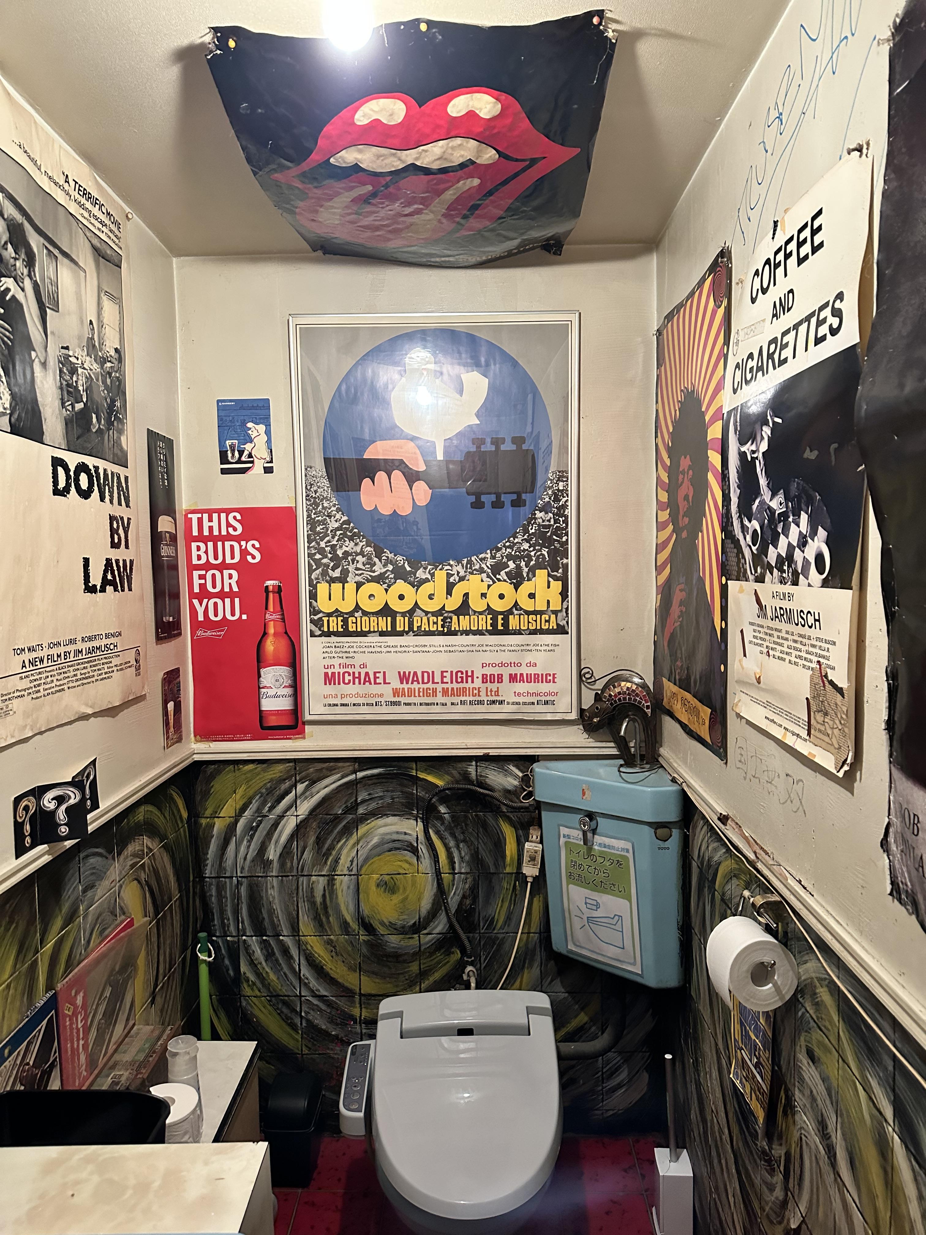 A picture inside the bathroom of The Flying Dutchman pub, which has posters and decorations all over the walls.