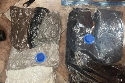 Two vacuum seal bags, one sealed with seven pieces of clothes and another unsealed with three pieces. 
