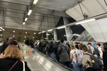 People are pictured at the escalator of a tube station.