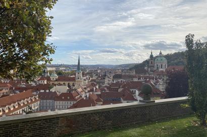A view of Prague from the gardens outside the Prague Castle. It is a sunny day with a few light clouds. 
