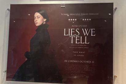 A deep-red promo poster at the Light House cinema, advertising the movie Lies We Tell, which came out in theaters October 13. Agnes O' Casey is on the poster, wearing a large black dress.