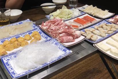 A table loaded with noodles, fish, and veggies, ready for hotpot.