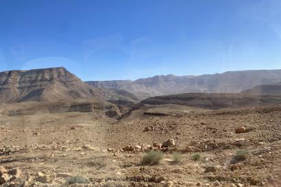 View out the bus window of flat-top desert mountains on the drive back from Merzouga