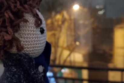 A doll resembling the iconic BBC series' "Sherlock" very own Sherlock staring out a window at the snow falling in Paris.