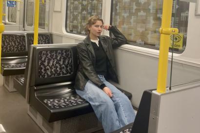 A college-aged girl sits on a subway
