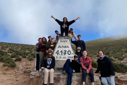 a group of us standing in front of a rock that describes the altitude of the region we were hiking near