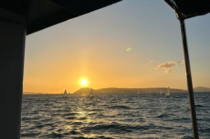 The sunset over the water in Split with boats in the background.