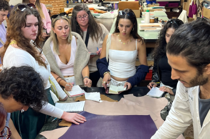 IES Abroad students examining textiles in a fashion demonstration.
