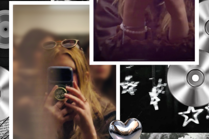 A photo of a woman with long blonde hair leaning on a railing with her elbows. She holds her phone in front of her face to capture the image of her reflection in the blurred tram. 