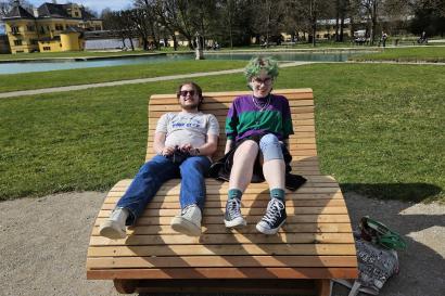 Two friends share a large bench in Salzburg, Austria.