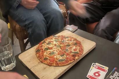 People playing Phase 10 and eating pizza