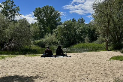 Friends sitting at the river on a sunny day in Salamanca