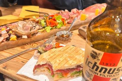 cutting board, ichnusa, and a proscuitt sandwich