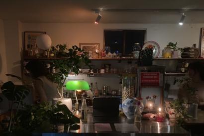A low-lit image of a bar at a restaurant I was eating dinner at. Most of the light is emitting from a green lamp.