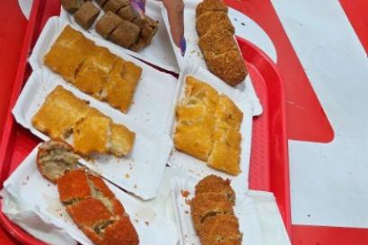 A sampling display of a saucy beef or cheese filling that is shaped into a breaded and fried ball. 