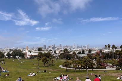 Picnic-goers enjoy the city skyline on a sunny day at San Francisco's Dolores Park.