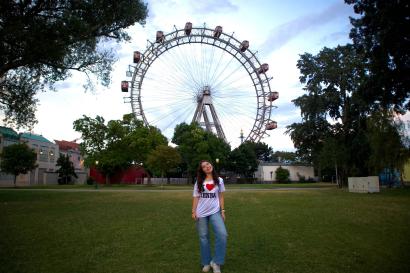 A girl in front of the Prater Ferris wheel