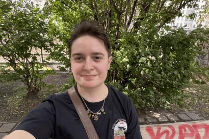 A selfie of the author on a bench with some trees in the background.