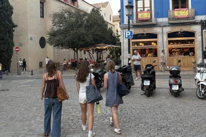 3 students walking through a plaza