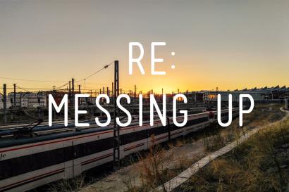 Train tracks at sunset with silhouette of overhead wires. This alt text was added with Al; accuracy may vary.