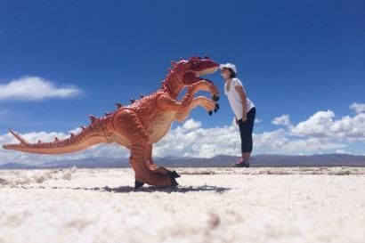 Student standing in Jujuy kissing a toy dinosaur