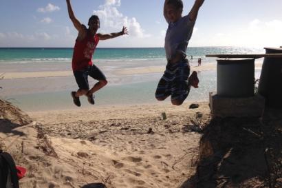 River view of London skyline with Big Ben and Parliament under cloudy sky.

Two people jumping joyfully on a sunny beach. This alt text was added with Al; accuracy may vary.