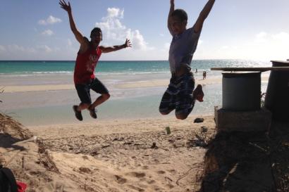 Two people jumping on a sunny beach