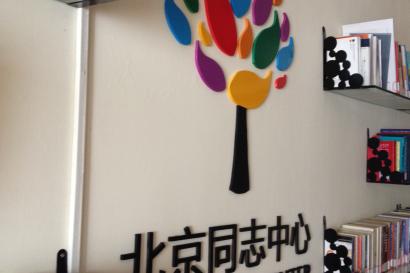 Beach with two people walking along a rocky shore, under a cloudy sky. This alt text was added with Al; accuracy may vary.