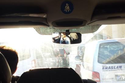 Child on sunny hillside, blue sky.  
Inside view of car, looking at city traffic. This alt text was added with Al; accuracy may vary.