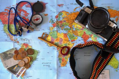 Map with camera, coins, compass, and a passport. This alt text was added with Al; accuracy may vary.
